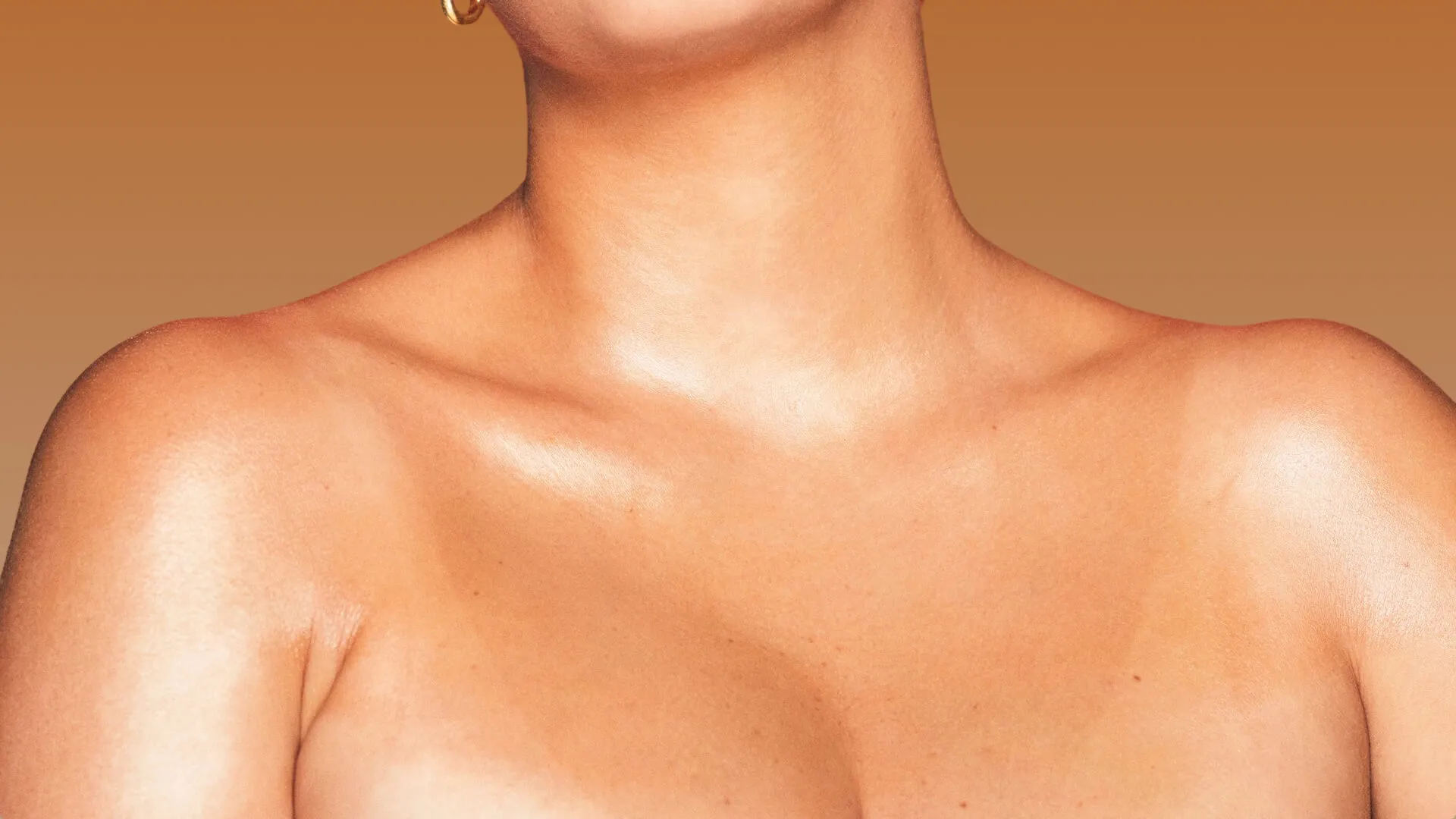 Photo of a woman’s spray tanned neck, chest, and upper breast area